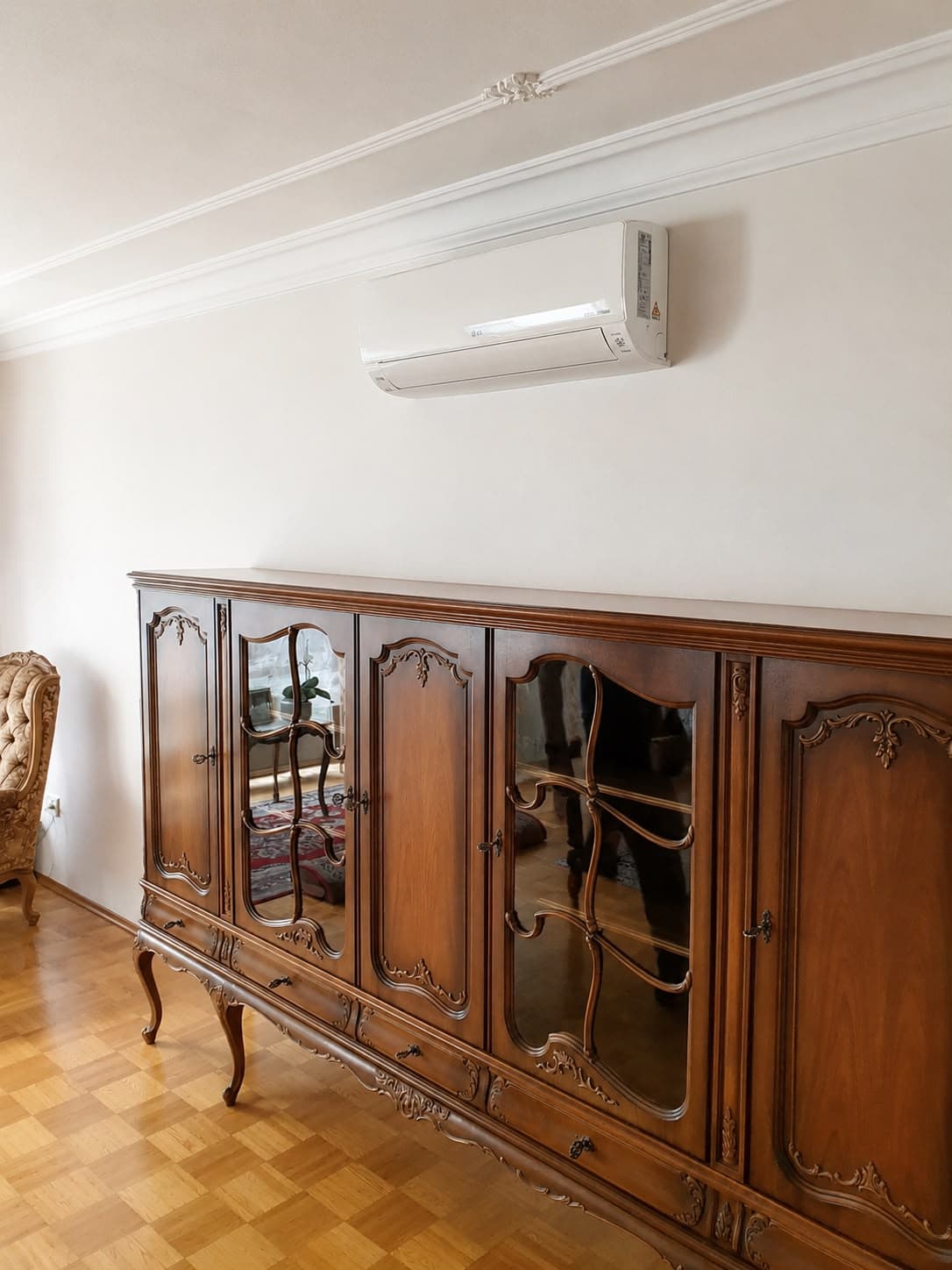 Innengerät der Klimaanlage über einem antiken Sideboard im Wohnzimmer eines Einfamilienhauses in Edingen